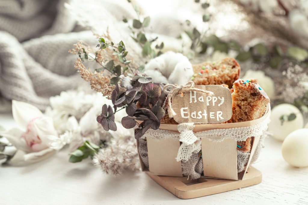 Happy Easter composition with pieces of Easter cake in a decorative basket and eggs.
