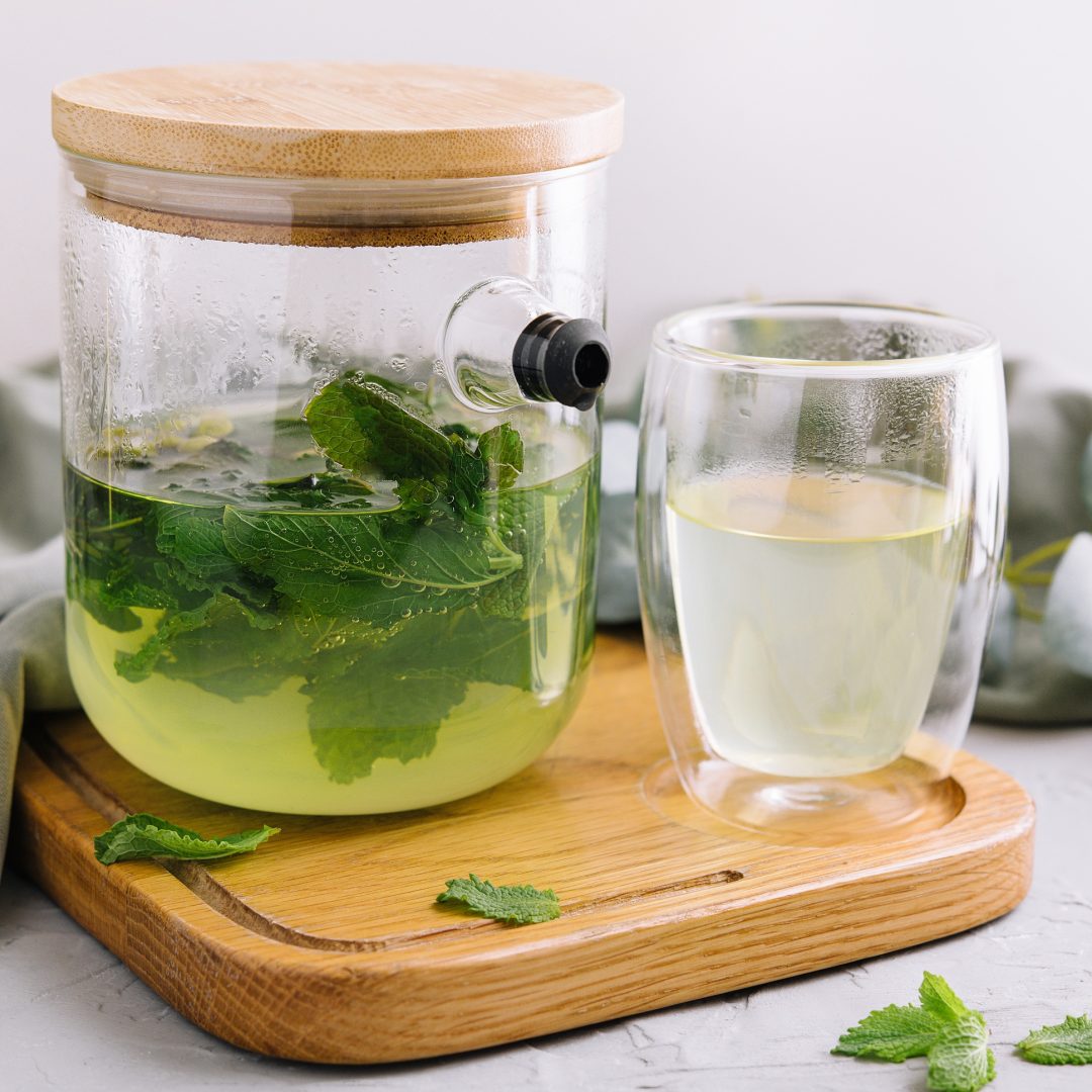 green tea in a jug and a cup with mint