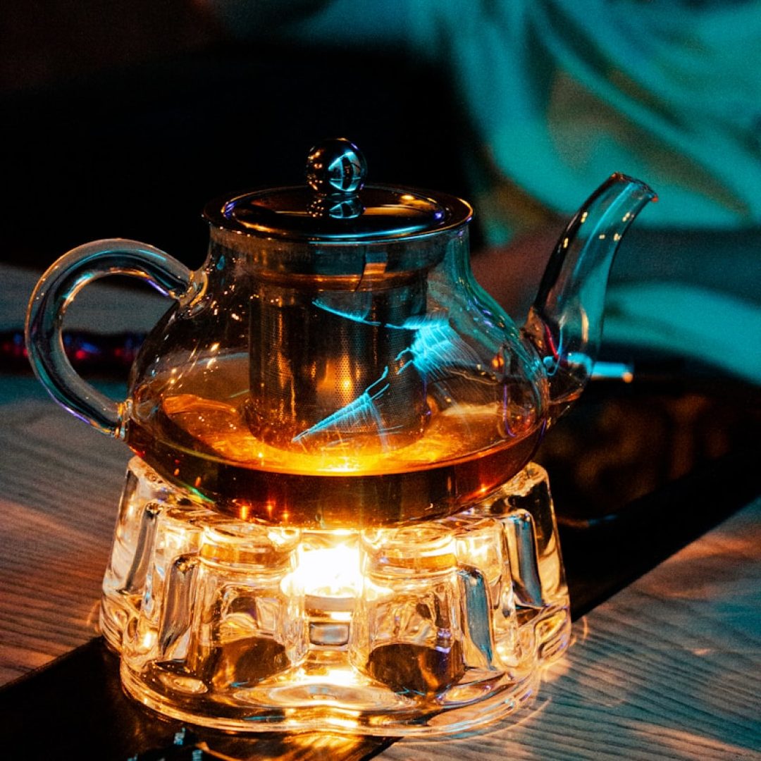 a glass tea pot with a light inside of it